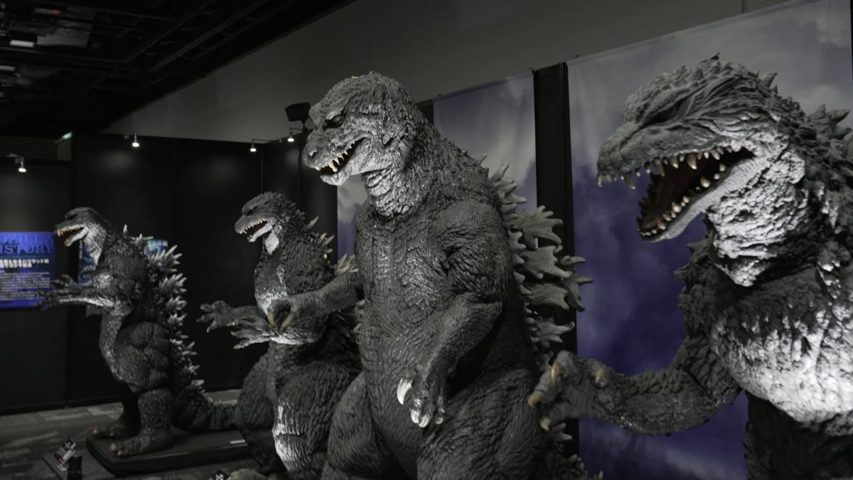 A line-up of standing figures of Godzilla through the years