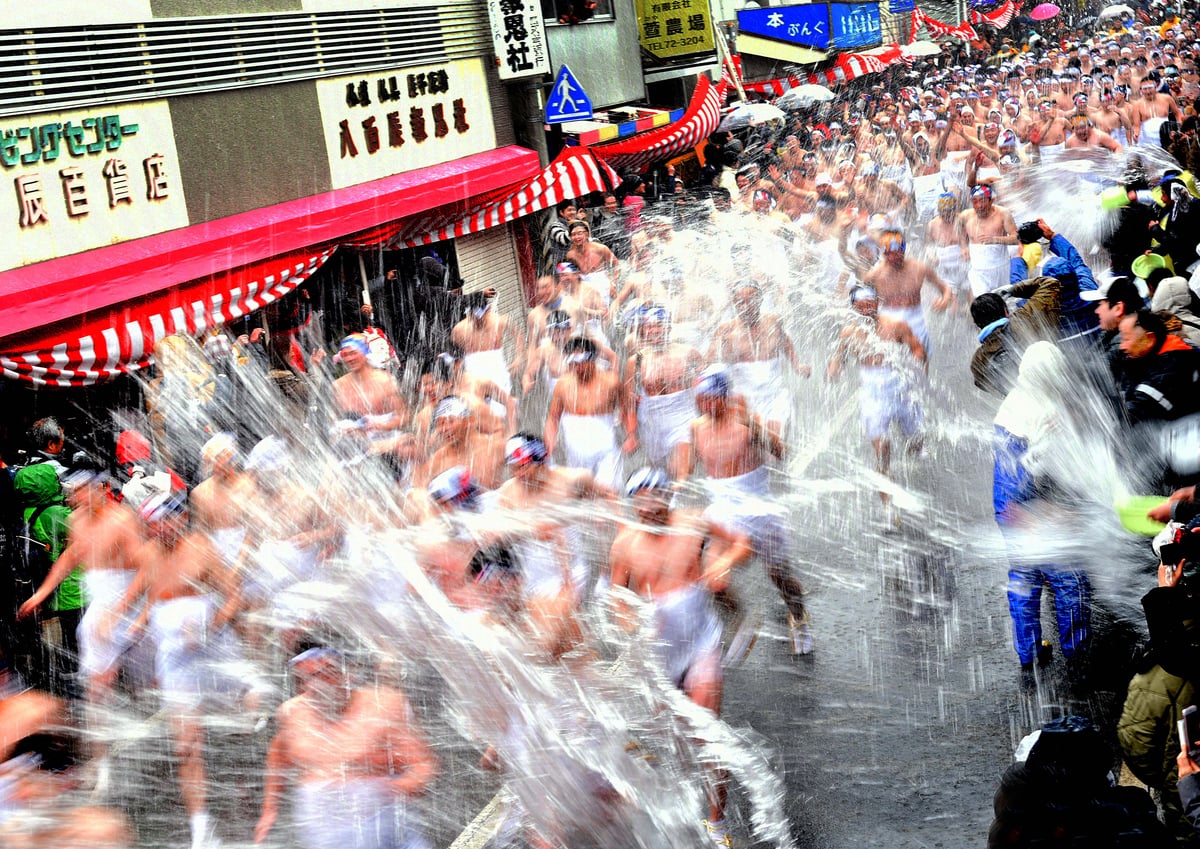 Participants in the Daito Ohara Mizukake Festival run through Ōhara’s main street as spectators splash them with icy water.