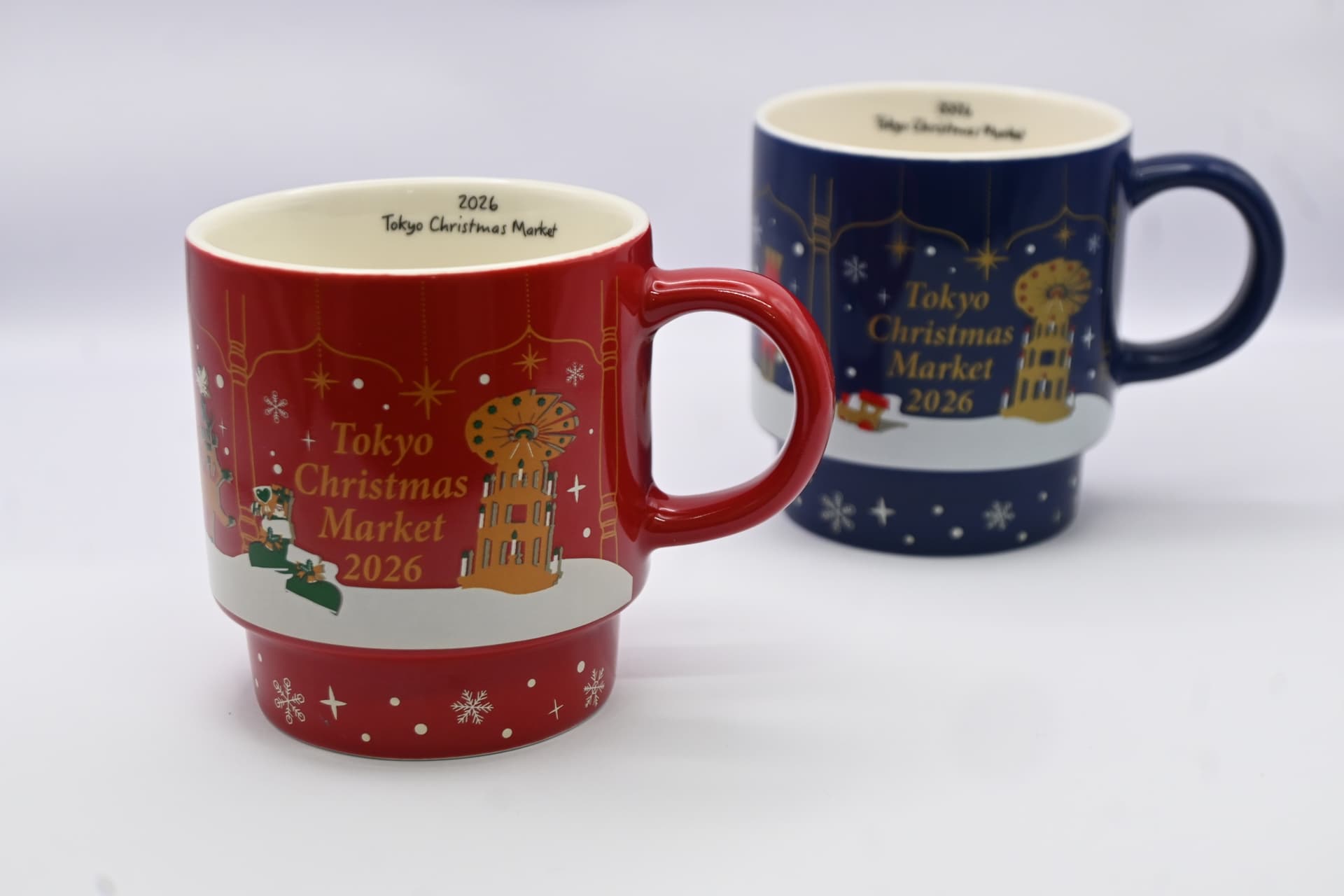 A red mug and a navy mug, both printed with Tokyo Christmas Market 2026 and a gold Christmas pyramid