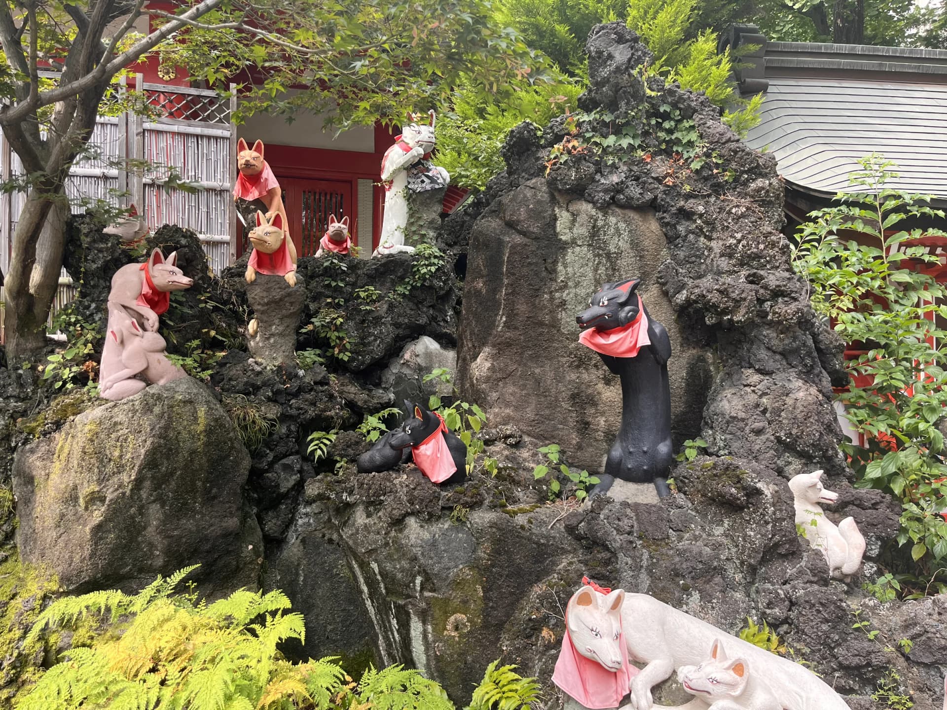 Fox statues arranged across the lava rockery — Keihin Fushimi Inari Shrine, Kawasaki, Kanagawa
