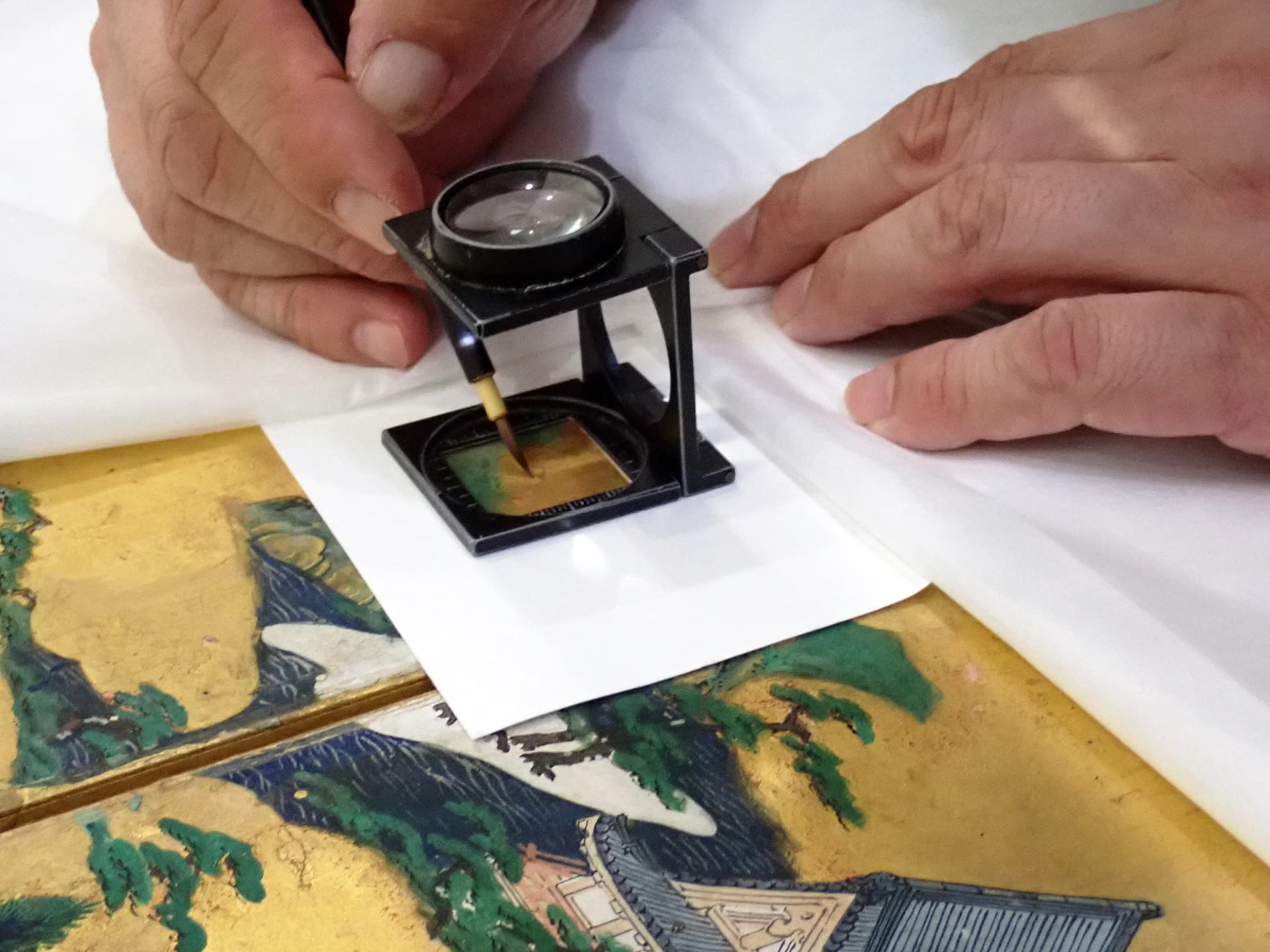 Close-up restoration work on the gold-leaf surface of the Uesugi Version of the Rakuchu Rakugai-zu Byobu folding screen
