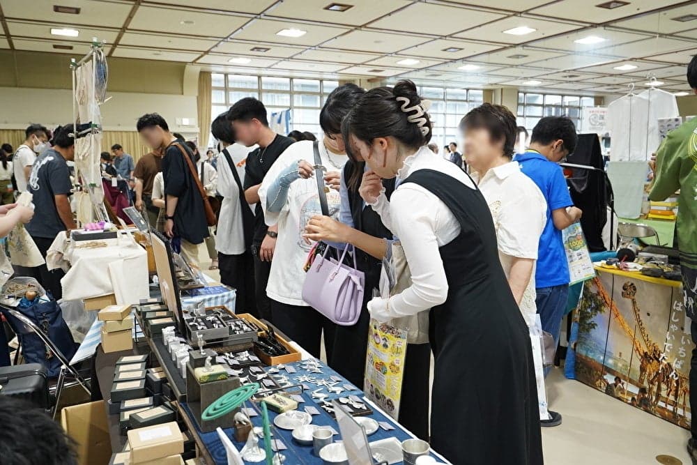 Visitors looking over small handmade pieces at a booth at a previous Hakubutsu Mania