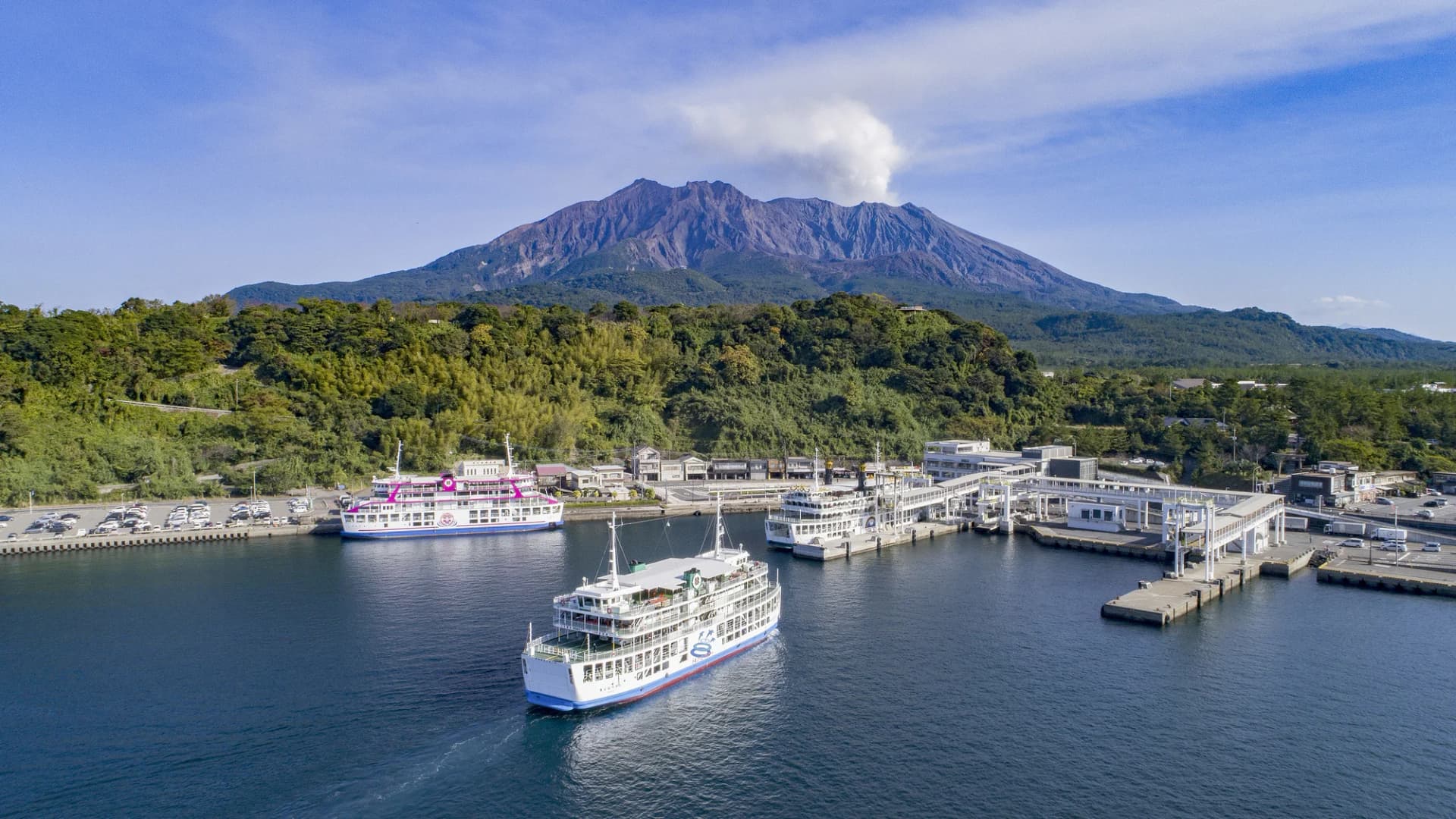 Ferries dock at Sakurajima Port beneath the active Sakurajima volcano, Kagoshima