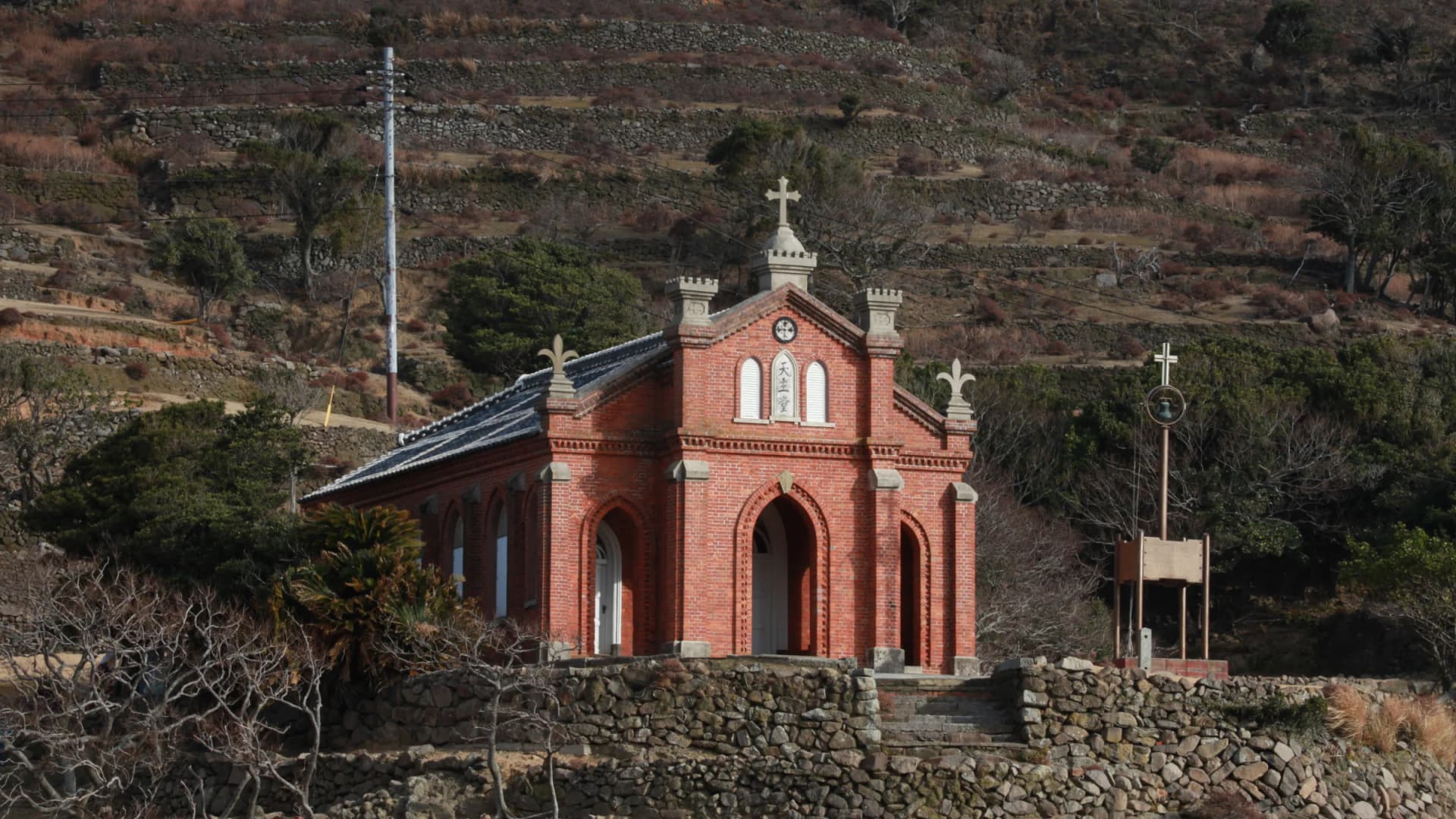 The red-brick Nokubi Church stands against the terraced hillsides of Nozaki Island, Nagasaki