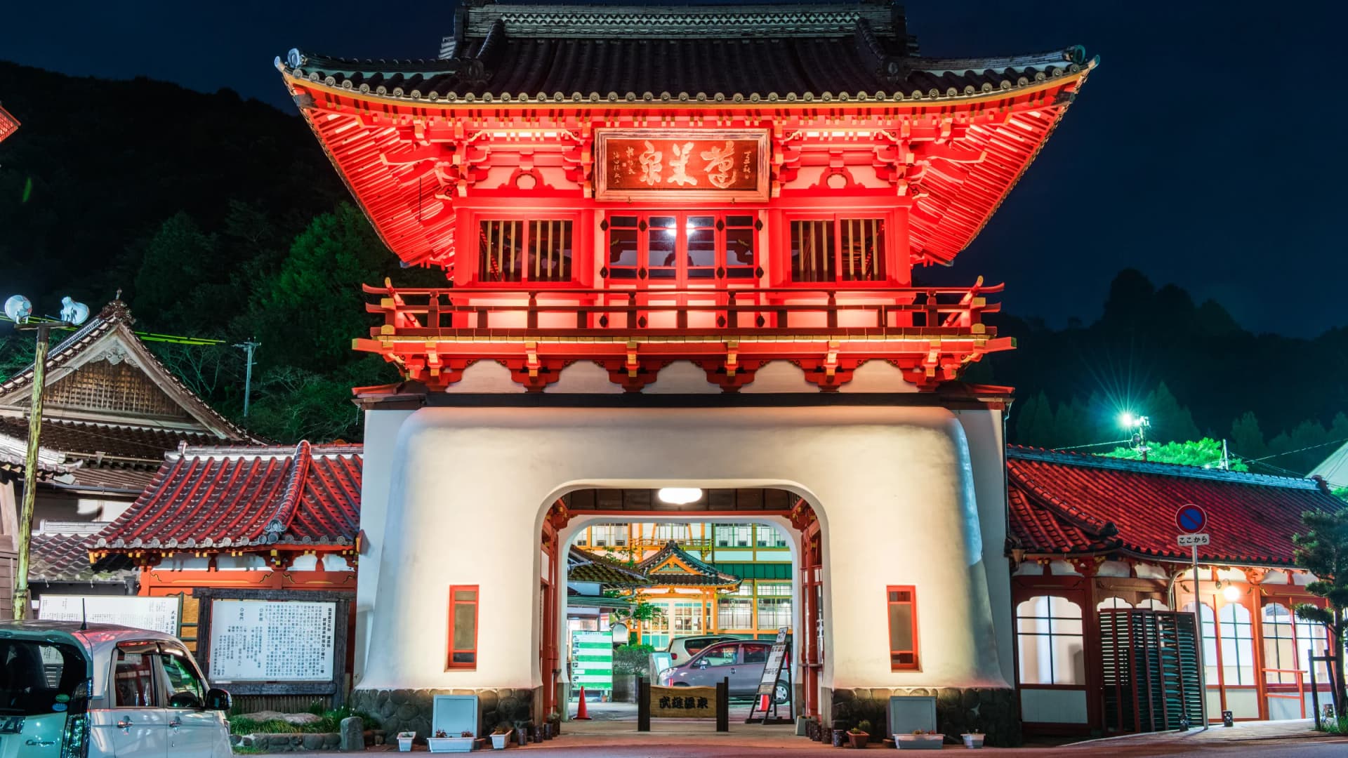 The iconic vermilion Romon gate of Takeo Onsen glows against the night sky, Saga