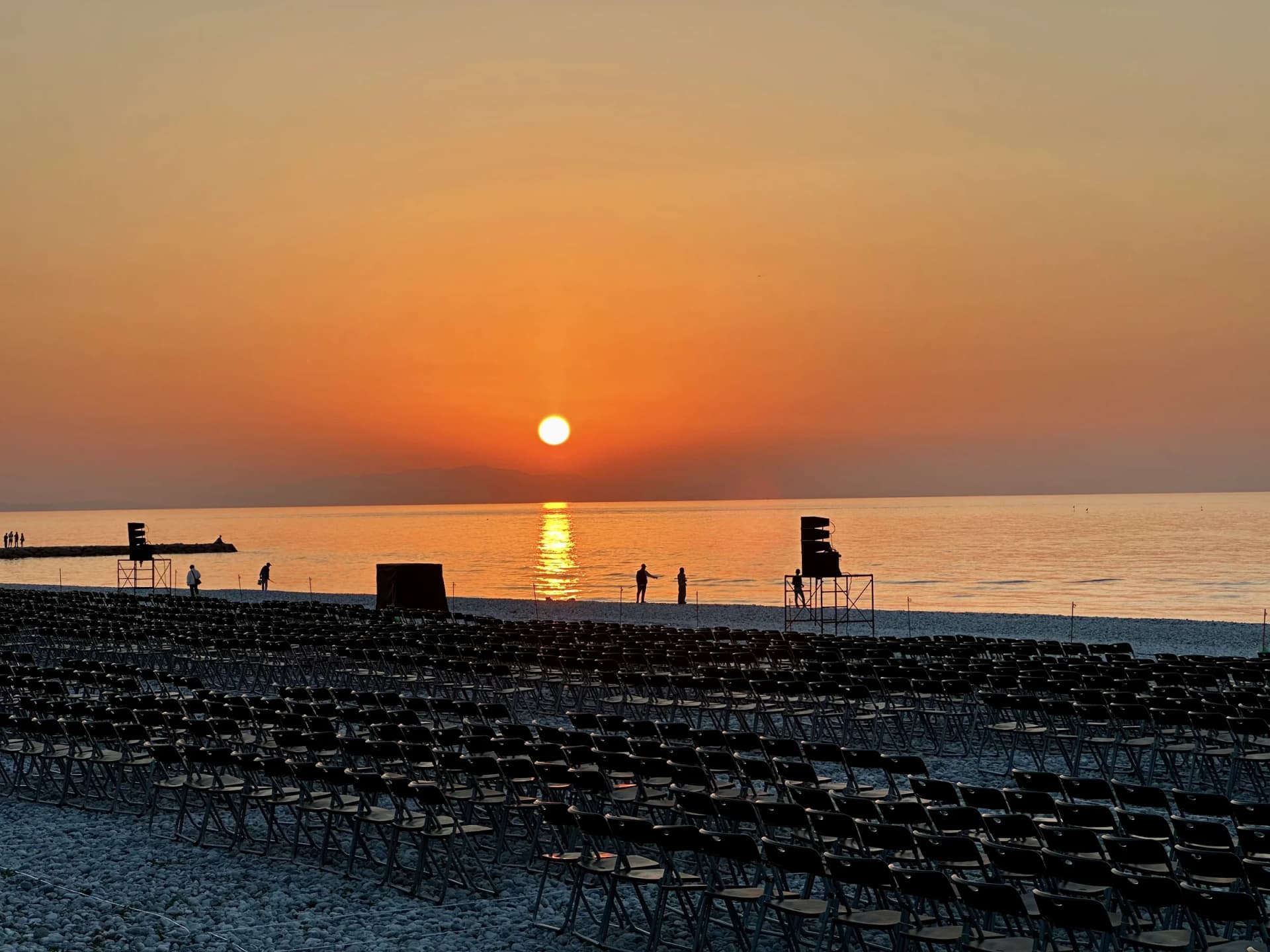 Rows of seating line Marble Beach as the sun sets over the sea ahead of an Osaka Art Fireworks event