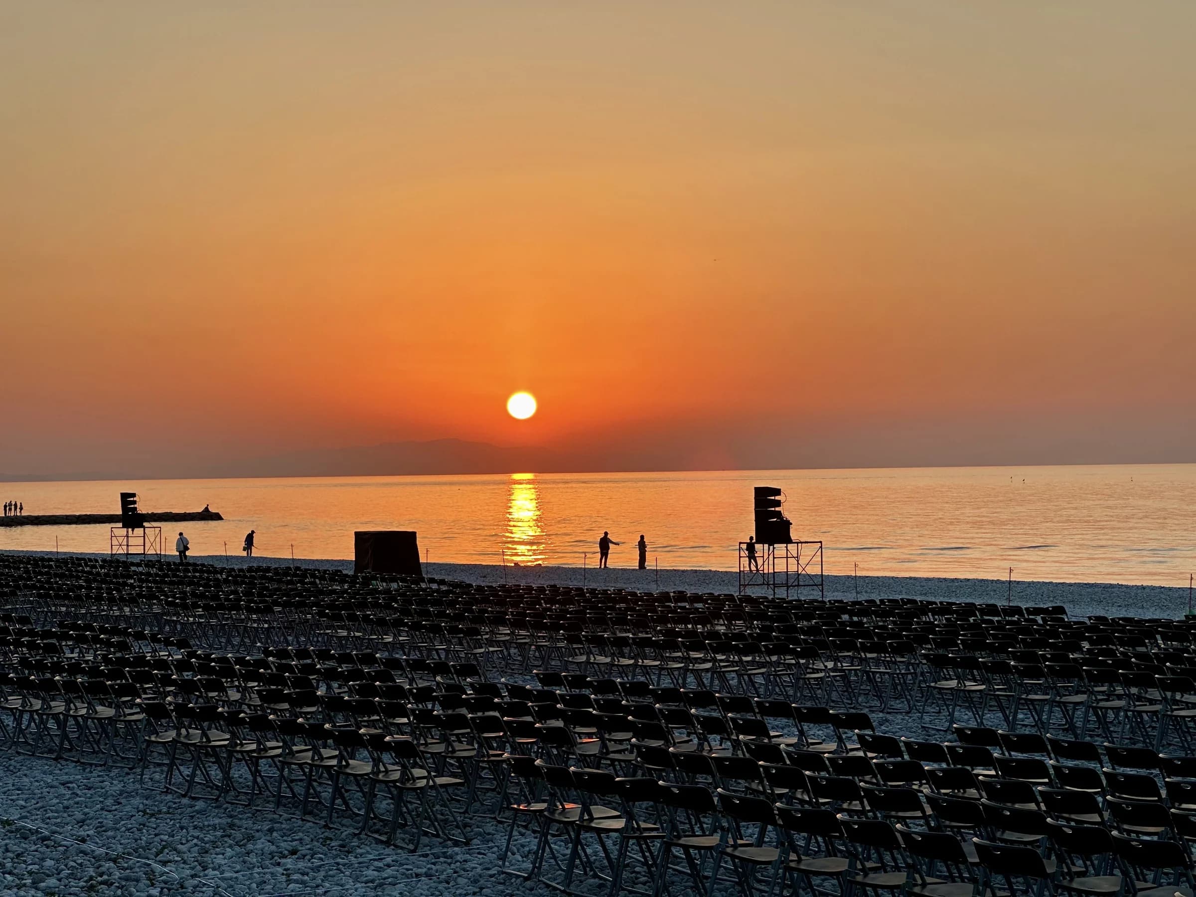 Rows of seating line Marble Beach as the sun sets over the sea ahead of an Osaka Art Fireworks event