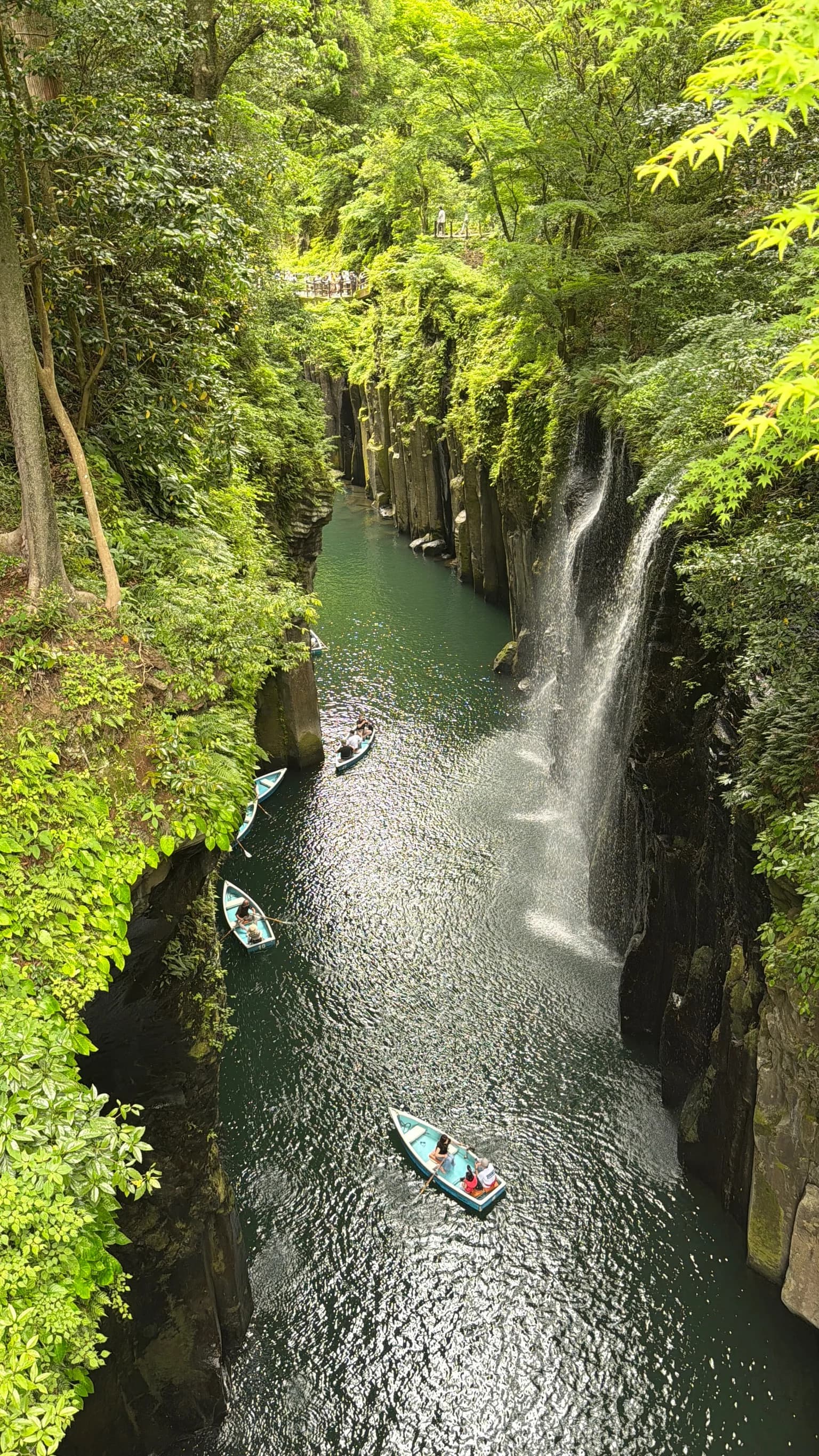 Rowboats drift beneath Manai Falls in Takachiho Gorge, Miyazaki
