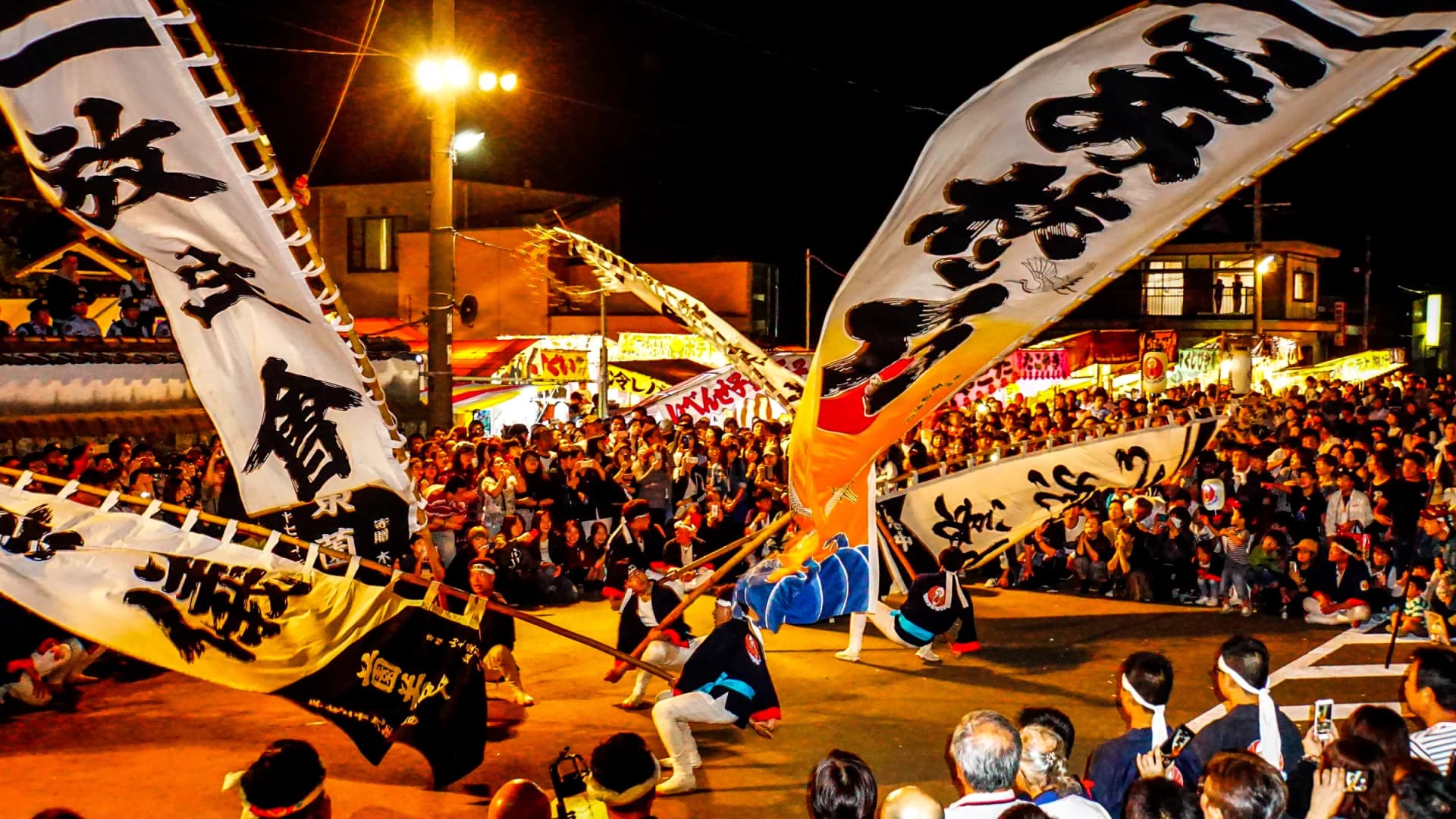 Bearers wield giant banners before the crowds at the Gobo Festival, Wakayama