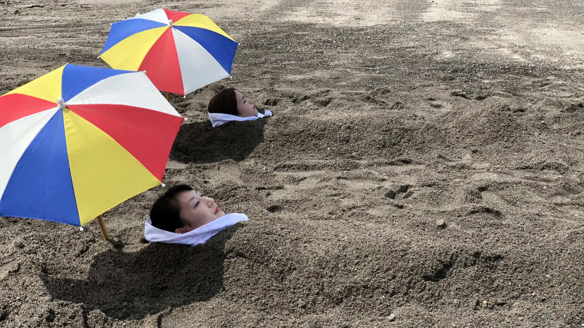 Bathers buried in naturally heated sand at Ibusuki's Saraku sand bath, Kagoshima