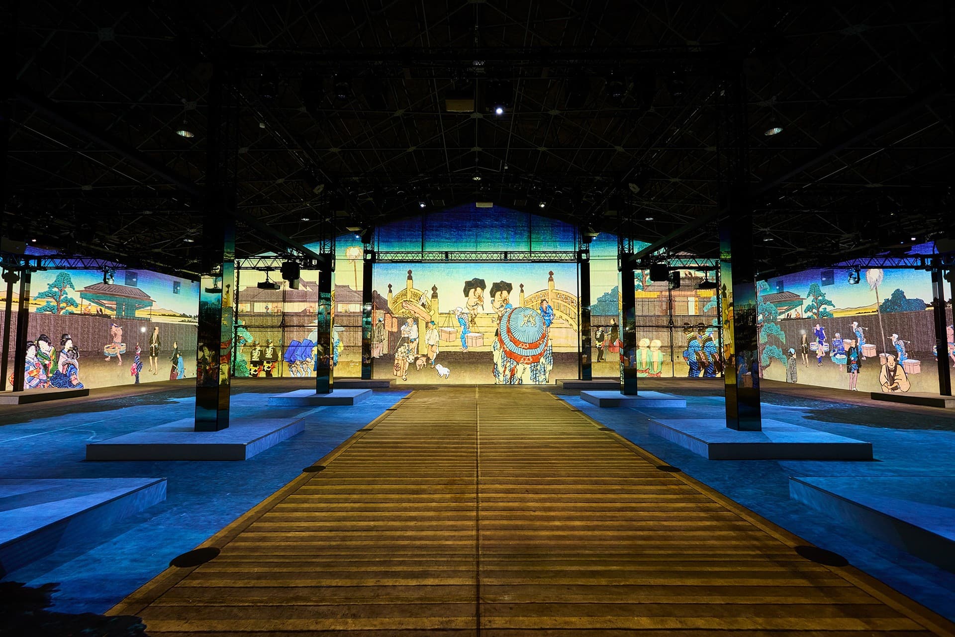 Ukiyo-e street scenes projected on the walls of a dark hall around a wooden walkway