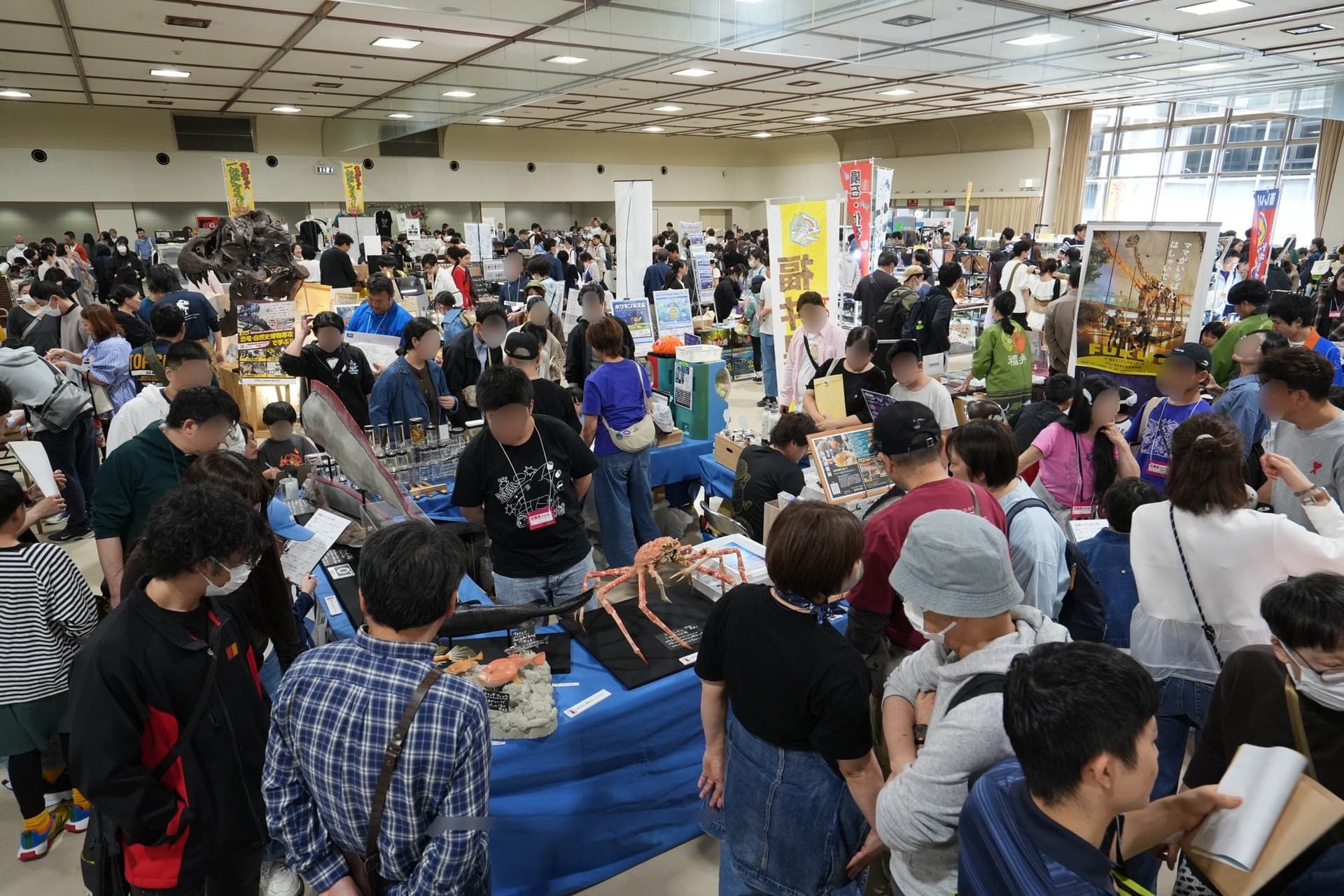 Visitors crowding the booths at a previous Hakubutsu Mania, with a large crab specimen laid out on one table