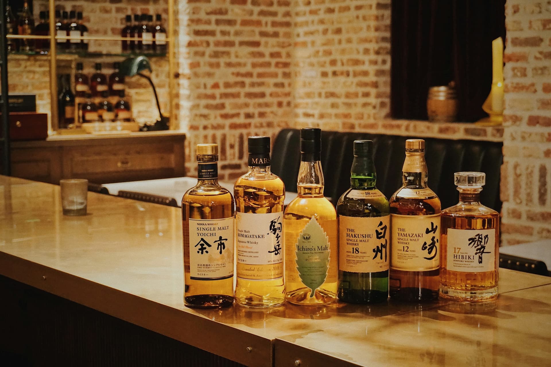 Japanese whiskies on a bar counter: Yoichi, Komagatake, Ichiro's Malt, Hakushu 18, Yamazaki 12 and Hibiki 17.