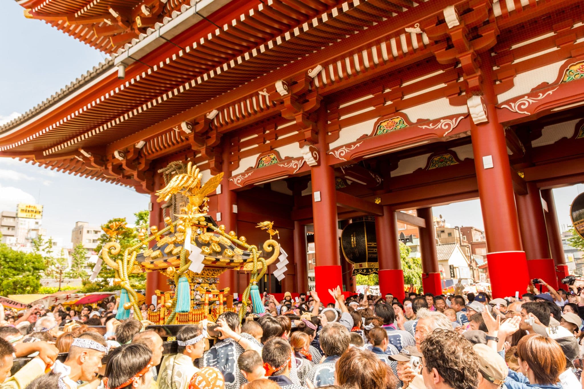 Crowds gather at Sensō-ji Temple's Thunder Gate as a golden mikoshi is paraded during the vibrant Sanja Festival in Asakusa, Tokyo.